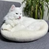 hvit kattehule som har blitt brettet og fungerer som en katteseng i myk ull